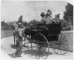 [3 people in horse-drawn carriage and another man getting on the carriage]