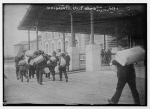 Immigrants carrying luggage, Ellis Island, New York