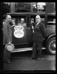 Stop when you see this sign. This is the new insignia plate the Bureau of Prohibition has adopted for use by prohibition agents in stopping suspected automobiles. In the photograph, from left to right, are; Prohibition Administrator Ames Woodcock, H.M. Lucious, secretary of the Automobile Club of Maryland, and Ernest M.Smith, vice- president of the A.A.A.