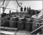 [Coast Guard Cutter, USS Seneca chasing and capturing a "rum runner" 1924: Prohibition agents examining barrels on boat]